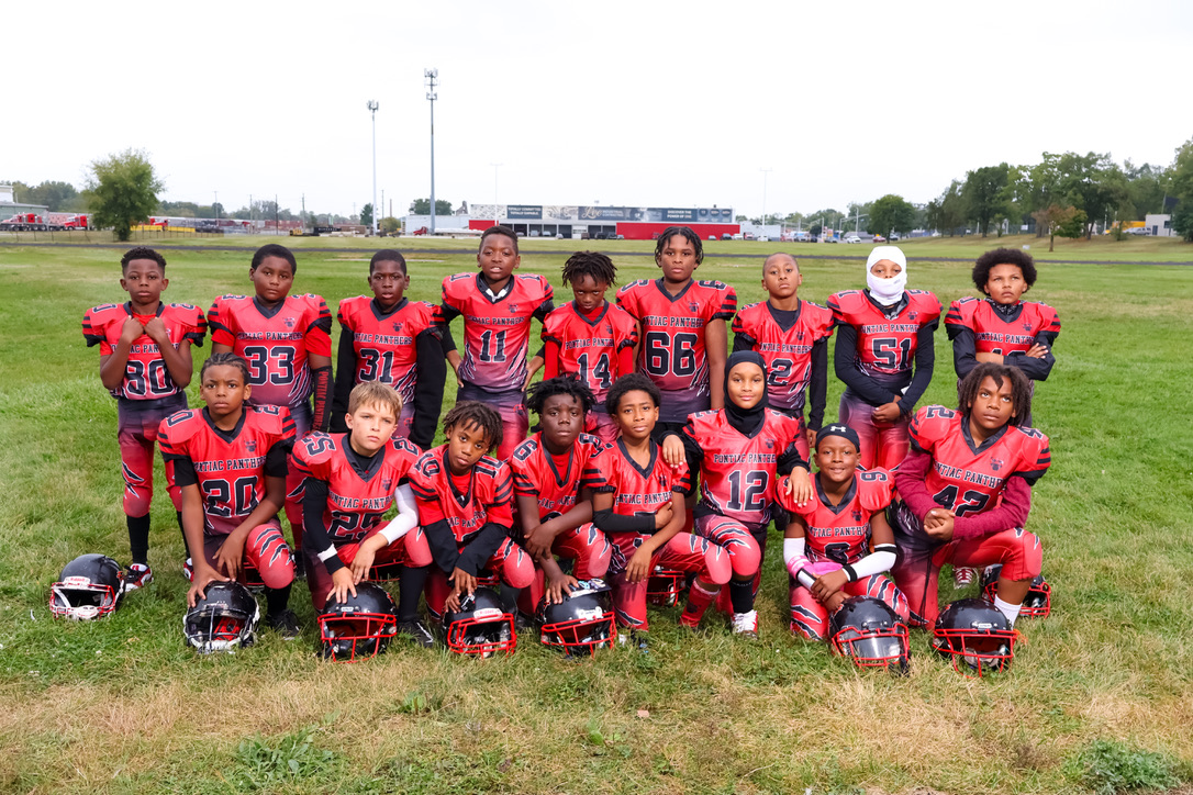 Full Pontiac Panthers team in red jerseys kneeling together on the field for a team photo