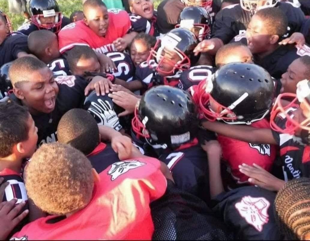Young Pontiac Panthers players celebrating in a team huddle